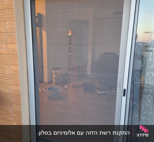 דלת רשת הזזה מאלומיניום מותקנת בפתח ויטרינה של מרפסת